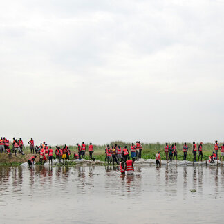 Workers rebuild a breached point of a dyke in Twic East, South Sudan. 